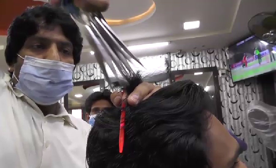 جھنگ کا ایک ہیئر ڈریسر دس قینچیوں کی مدد سے نوجوانوں کی کٹنگ کرنے میں مصروف